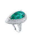 A top left view of a white gold emerald engagement ring pear shaped