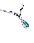 Left sight of a white gold women's emerald necklace pear cut encircled by a halo diamond on a white background