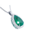 Pear-shaped emerald pendant with diamond halo and intricate 14K white gold setting on a chain.