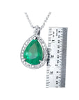 8.64 ct. pear-shaped emerald pendant with halo diamonds in 14K white gold, next to a ruler.