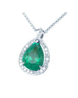 Emerald green teardrop pendant with diamond halo on a left side position topside visible.