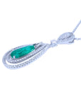Teardrop emerald pendant with double diamond halo in 18K white gold.