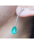 Teardrop emerald green gemstone earring on a person's ear
