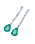 Pear shape 5.05 ct. emerald drop earrings in 18K white gold with diamond accents.