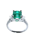 Anillo de compromiso de oro blanco 18k con esmeralda colombiana ovalada y diamantes trapezoide.