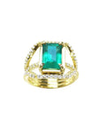 Anillo de oro 18k con esmeralda colombiana verde y tres filas de diamantes naturales.