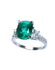 Anillo de compromiso de oro blanco 18k con esmeralda colombiana y diamantes trapezoidales.