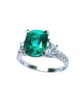 Anillo de compromiso de oro blanco 18k con esmeralda colombiana y diamantes trapezoidales.