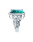 Anillo de compromiso 18k con esmeralda colombiana rectangular de 2.99 ct. verde medio, rodeada de diamantes.