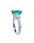 Anillo de compromiso de oro blanco 18k con esmeralda colombiana ovalada y diamantes trapezoide.