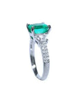 Anillo de compromiso de oro blanco 18k con esmeralda colombiana ovalada y diamantes trapezoide.