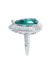 Anillo de oro blanco 14k con esmeralda colombiana corte pera de 3.35 ct rodeada de diamantes.