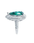 Anillo de oro blanco 14k con esmeralda colombiana corte pera de 3.35 ct rodeada de diamantes.
