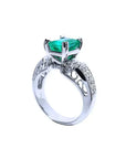 Anillo de mujer en oro blanco de 18K con esmeralda colombiana verde profundo y diamantes, estilo antiguo.