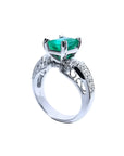 Anillo de mujer en oro blanco de 18K con esmeralda colombiana verde profundo y diamantes, estilo antiguo.
