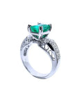 Anillo de mujer en oro blanco de 18K con esmeralda colombiana verde profundo y diamantes, estilo antiguo.