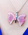 Pink natural agate butterfly pendant with sterling silver setting on a silver necklace.