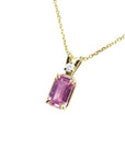 Genuine emerald cut pink sapphire and diamond pendant in 14k gold.