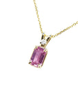 Genuine emerald cut pink sapphire and diamond pendant in 14k gold.