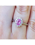 Natural pink sapphire ring for women halo diamond in 14k white gold, on a finger.