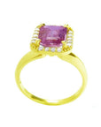 Emerald-cut pink sapphire ring with diamond halo in 14K yellow gold.