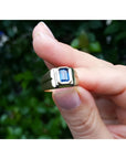 Men's 14k yellow gold pinky ring with a rectangular, medium dark blue sapphire, bezel set.