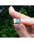 Men's 14k yellow gold pinky ring with a rectangular, medium dark blue sapphire, bezel set.