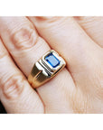 Gold ring with a blue natural sapphire gemstone on a hand