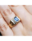 Men's 14k yellow gold pinky ring with a rectangular, medium dark blue sapphire, bezel set.