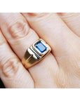 Men's 14k yellow gold pinky ring with a rectangular, medium dark blue sapphire, bezel set.