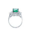 Ring with a natural emerald and diamond accents on a lateral profile view.