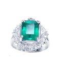 Platinum emerald ring for women and diamond accents on a topside view position.