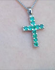 Emerald cross pendant necklace crafted in 18k white gold