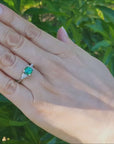 Round cut emerald and trillion side diamond ring