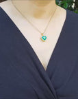 Heart shaped emerald pendant halo diamond in 18k yellow gold.