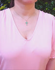 Emerald cross pendant necklace made in 18k yellow gold.