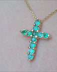 Real emerald cross pendant necklace in 14k yellow gold.