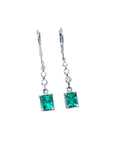 14K white gold dangle earrings with square Colombian emeralds and diamond accents.