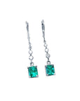 14K white gold dangle earrings with square Colombian emeralds and diamond accents.