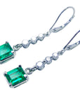 Left side profile and top view of a pair of emerald and diamond dangle earrings
