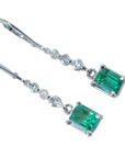 Top view of a pair of white gold Emerald dangle earrings white gold
