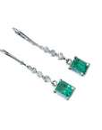 14K white gold dangle earrings with rectangular Colombian emeralds and clear accent stones.