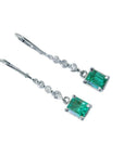 14K white gold dangle earrings with rectangular Colombian emeralds and clear accent stones.