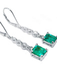 Pair of emerald dangle earrings, right profile top view