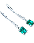 14k gold emerald dangle earrings right side fron view on a white background
