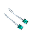 14K white gold dangle earrings with emerald-cut Colombian emeralds and diamond accents.