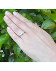 14K white gold ring with a princess cut diamond center and two trillion side diamonds on a hand.