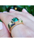 Men's 18K yellow gold ring with a rectangular green emerald and two accent diamonds.
