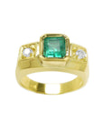 Gold ring with a natural colombian emerald and two diamonds on a white background