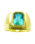 Topside view of a yellow gold emerald ring for men with bezel setting.